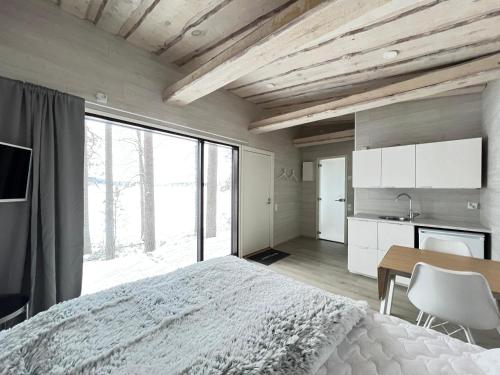 a bedroom with a bed and a table and a large window at Private High Quality Suite by the Lakeside in Jyväskylä