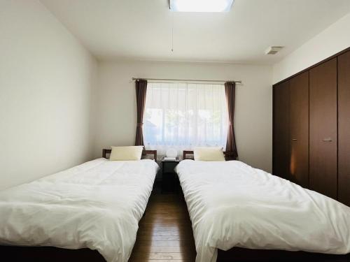 TaikiにあるMidoricho Guest House - Vacation STAY 15204の窓のある小さな部屋にベッドが2つある