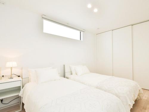 two beds in a bedroom with white walls at Seagull east coast Awaji - Vacation STAY 21943v in Awaji