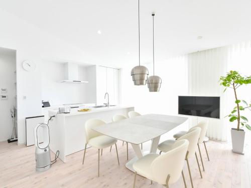 a white kitchen with a white dining table and chairs at Seagull east coast Awaji - Vacation STAY 21943v in Awaji