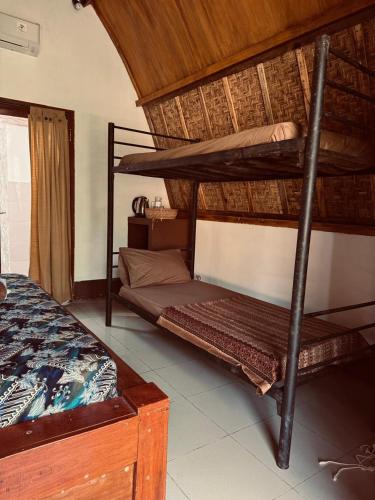 a bedroom with two bunk beds in a room at Rising Sun Bungalows in Gili Meno