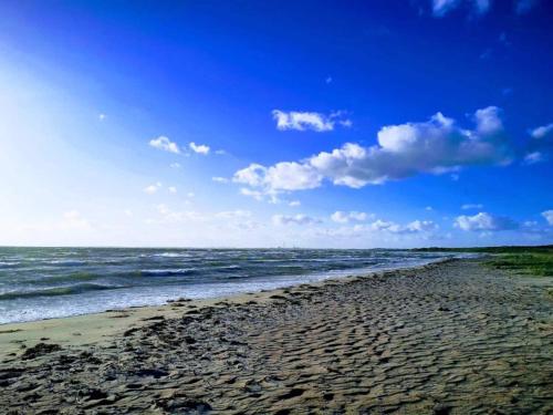a beach with the ocean on a cloudy day at 6 person holiday home in Gørlev in Gørlev