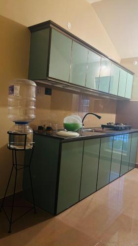 a kitchen with green cabinets and a counter with a sink at Venice villa varkala cliff -luxurious rooms and apartments in Varkala