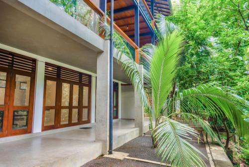 a house with a palm tree in front of it at Paradise Itzu in Kandy