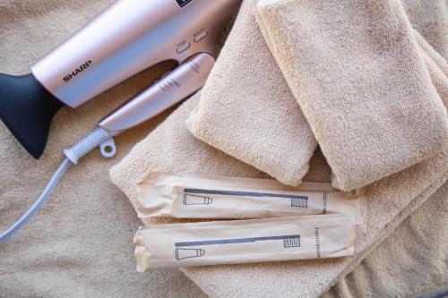 three toothbrushes and a hair dryer on a towel at La-gum - Vacation STAY 23975v in Inatori