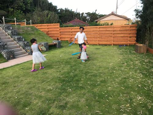 a man and two children playing baseball in a yard at FARMER'S FIELDZ - Vacation STAY 42161v in Hongō