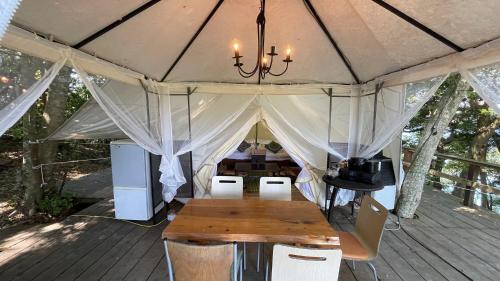 ein Zelt mit einem Tisch und Stühlen darin in der Unterkunft Shimanto Yamamizuki - Vacation STAY 36959v in Shimanto