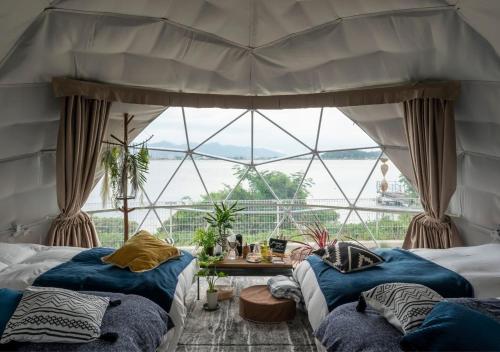 two beds in a room with a large window at Glamping Base IZUMO "Lakeside Hot Spring Hotel Kun - Vacation STAY 42024v in Izumo