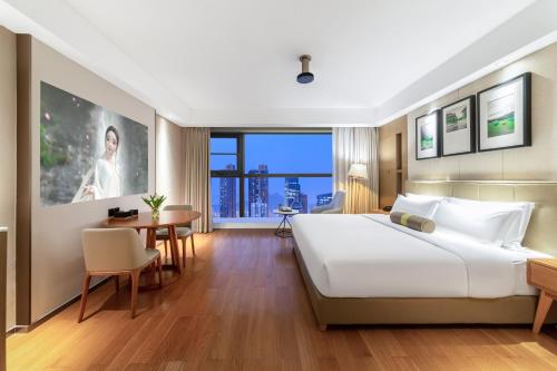 a hotel room with a large bed and a table at Chengdu Yueming Hotel,2-minute walk to Zhongba Subway ,close to Kuanzhai Alley and Chunxi Road,Free laundry, Free coffee, Chengdu food,English communication well,Private travel advice in Chengdu