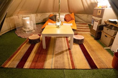 une tente avec une table et deux tabourets à l'intérieur dans l'établissement Shirasu-Ojiro FLORA Campsite in the Natural Garden - Vacation STAY 00655v, à Shirasu