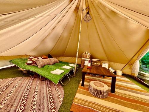 a tent with a bed and a table in it at Shirasu-Ojiro FLORA Campsite in the Natural Garden - Vacation STAY 00652v in Shirasu