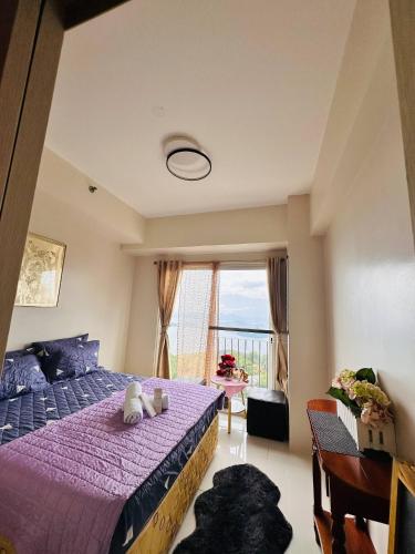 a bedroom with a purple bed and a window at Recharge Chamber Simoy in Kaybagal