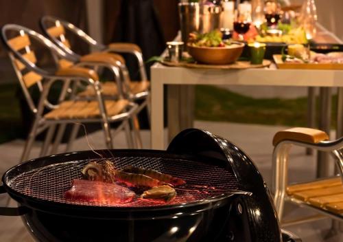 a grill with meat on it with a table of food at Glamping Base IZUMO "Lakeside Hot Spring Hotel Kun - Vacation STAY 42012v in Izumo