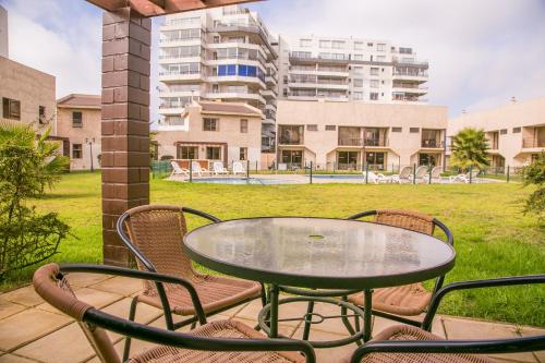 a patio with a table and chairs and a building at Cabañas Las Añañucas IV in La Serena