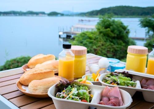 a table with plates of food and bottles of orange juice at Glamping Base IZUMO "Lakeside Hot Spring Hotel Kun - Vacation STAY 42019v in Izumo