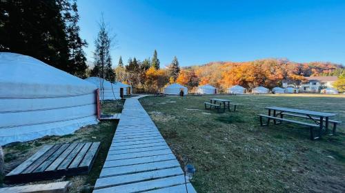 a group of tents in a field with benches at mini mongolia campsite - Vacation STAY 42129v in Makito