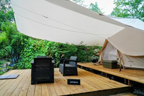 a tent on a wooden deck with a table and chairs at Glamping Azumino BASE Polecan - Vacation STAY 32549v in Azumino