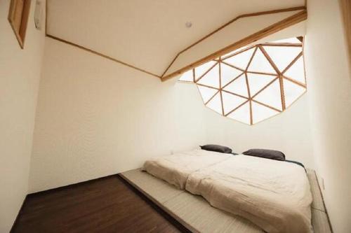 a bedroom with a bed in a room with a window at HOLE37 - Vacation STAY 42189v in Hōjō