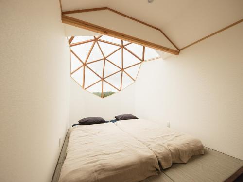 a bedroom with a large bed with a window at HOLE37 - Vacation STAY 42190v in Hōjō