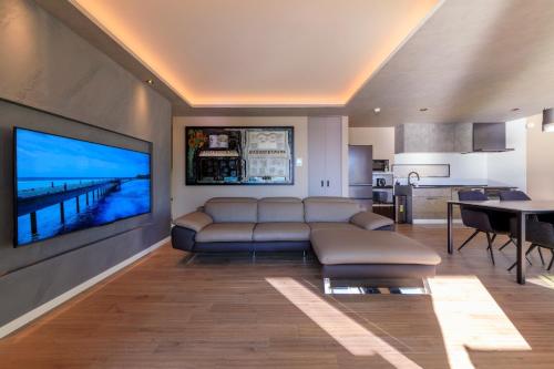 a living room with a couch and a television on a wall at GranTerace Sun - Vacation STAY 15256 in Numazu