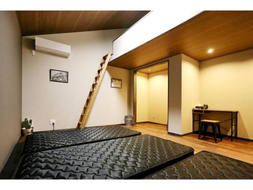 a room with a black mattress and a ladder at Guest House Garage IMAZU - Vacation STAY 15208 in Takashima