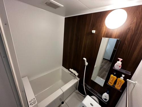 a bathroom with a tub and a toilet and a mirror at Tsunageru Aomori Yasukata - Vacation STAY 25824v in Aomori