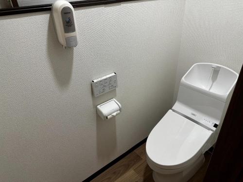 a bathroom with a toilet and a phone on the wall at Tsunageru Aomori Yasukata - Vacation STAY 25824v in Aomori