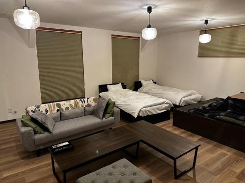a living room with a couch and a bed at Tsunageru Aomori Yasukata - Vacation STAY 25824v in Aomori
