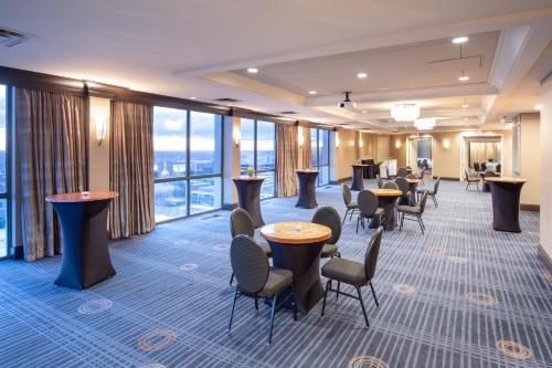 a hotel lobby with tables and chairs and windows at Crowne Plaza Kansas City Downtown by IHG in Kansas City
