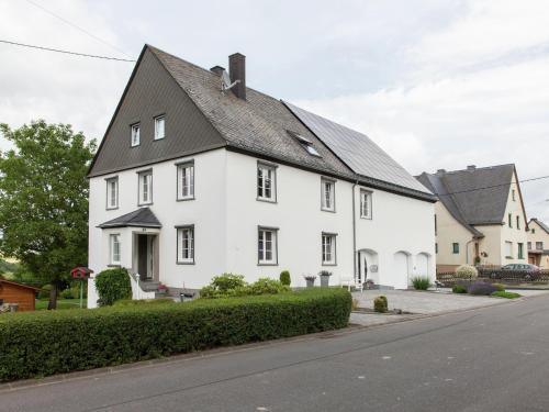 a white house with a black roof on a street at Morscheid-Riedenburg Stay in Morbach