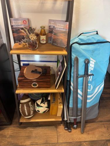 a shelf with baseball equipment and a bag on it at Penzion pod Hazmburkem in Klapý