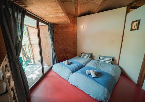 a bedroom with a large bed with blue sheets at OvalMountainLodge - Vacation STAY 34543v in Hakuba