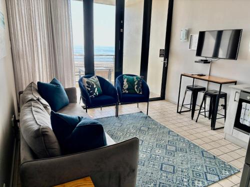 a living room with a couch and a television at Durban Point Waterfront, 505 Quayside 40 Canalquay Rd in Durban
