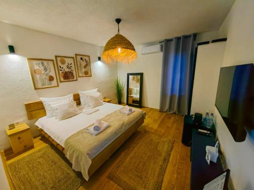 a bedroom with a large bed and a tv at Garden Relax Bungalow, 2 Deluxe Rooms, Shared Pool and Parking in Banja Luka