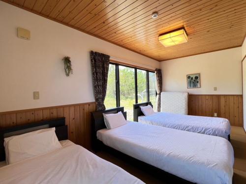 two beds in a room with a window at Inori Resort SORAKAZE - Vacation STAY 49443v in Shushi