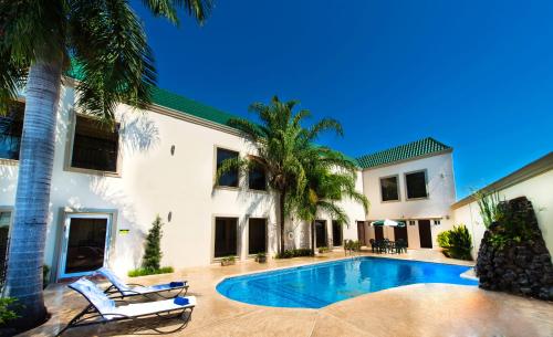a swimming pool in front of a house at Hotel Brio Inn in Ciudad Victoria