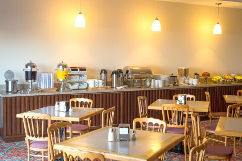 a restaurant with tables and chairs and a counter at Hotel Brio Inn in Ciudad Victoria