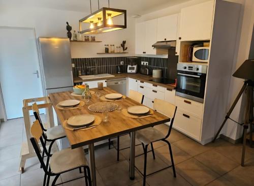 a kitchen with a wooden table and chairs at Charmante maison de vacances in Saint-André-de-Cubzac