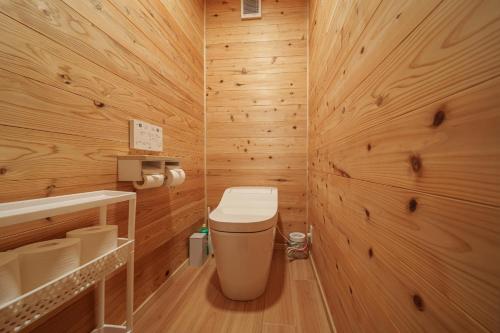 a bathroom with a toilet in a wooden wall at Osugi no Yado - Vacation STAY 43977v in Yufuin
