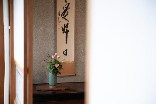 a vase with flowers in front of a mirror at Setouchi base - Vacation STAY 48109v in Mitoyo