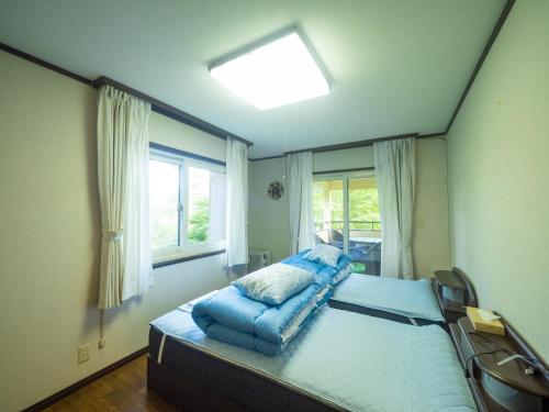 a bedroom with a bed with blue pillows on it at Sanso Seseragi - Vacation STAY 15301 in Nasu