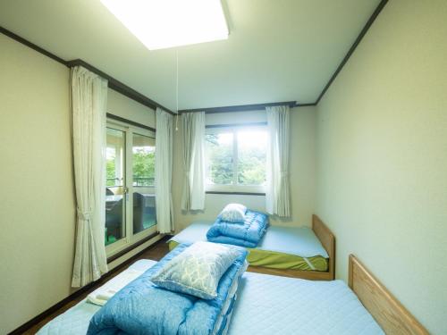 two beds in a room with a window at Sanso Seseragi - Vacation STAY 15301 in Nasu