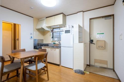 a kitchen with a table and a white refrigerator at maison elegance - Vacation STAY 15341 in Tokyo