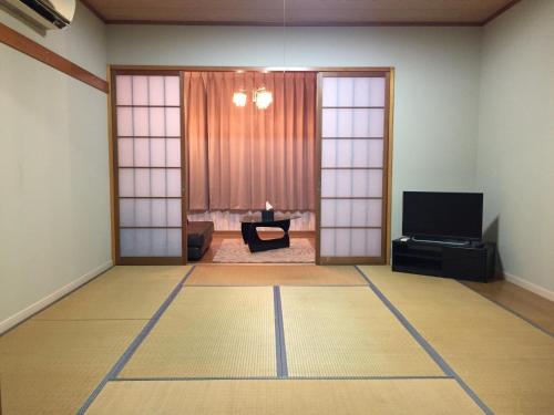 a room with a living room with a television and a door at Maison dEssence - Vacation STAY 52767v in Izu