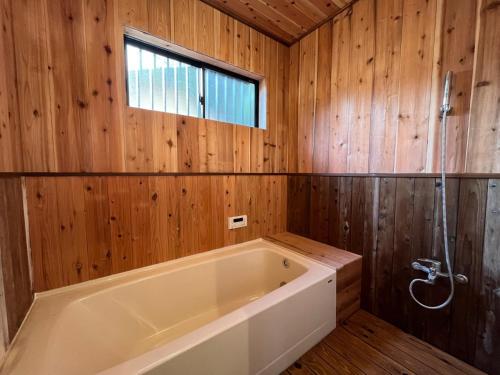 a bath tub in a wooden bathroom with a window at Private Garden Otaki - Vacation STAY 89486v in Ōtaki