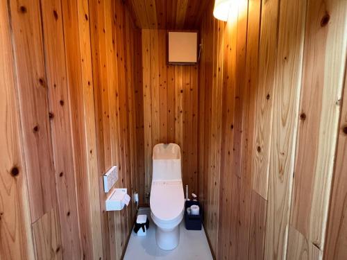 a bathroom with a toilet in a wooden wall at Private Garden Otaki - Vacation STAY 89486v in Ōtaki