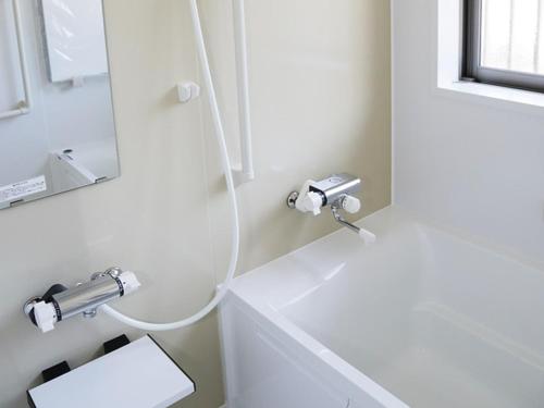 a white bathroom with a sink and a mirror at Hisetsu no Taki Campsite - Camp - Vacation STAY 42072v in Ōzato