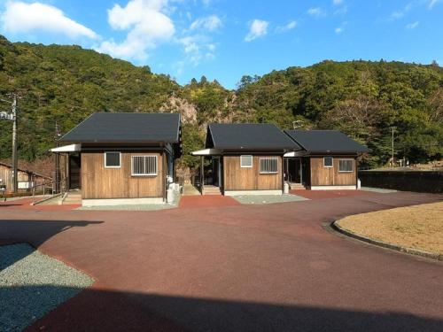 a couple of small wooden buildings with a driveway at Hisetsu no Taki Campsite - Camp - Vacation STAY 42072v in Ōzato