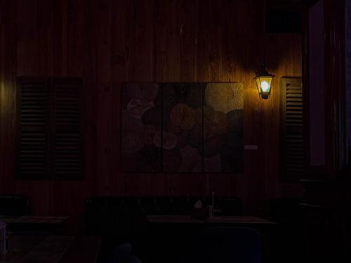 a dark room with a lamp and a picture on the wall at Pacific Hotel in Phnom Penh