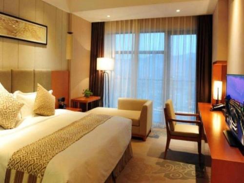 a hotel room with a large bed and a desk at Suzhou Qingshan Conference Center in Suzhou